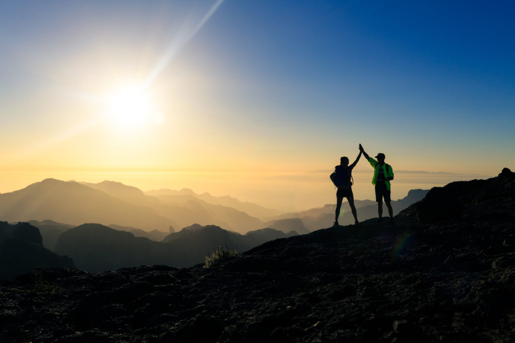 Hikers celebrating a mountainous climb.